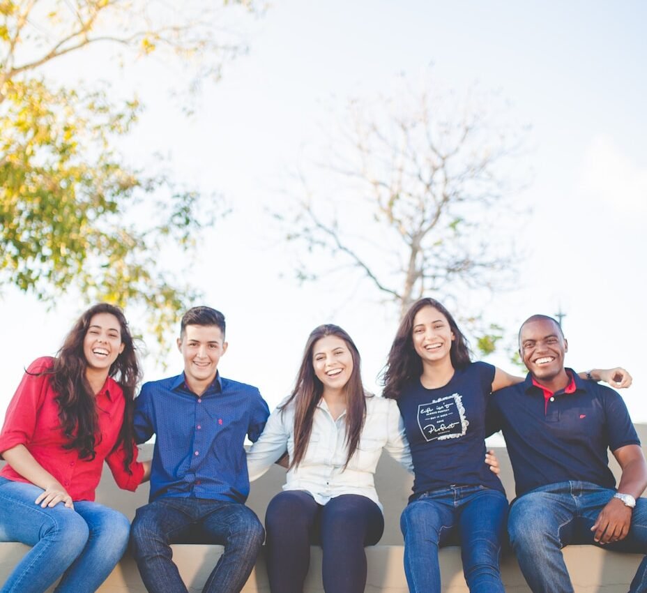 group of people sitting on bench near trees duting daytime